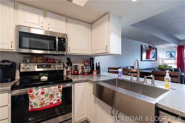 kitchen featuring white cabinetry, sink, and appliances with stainless steel finishes