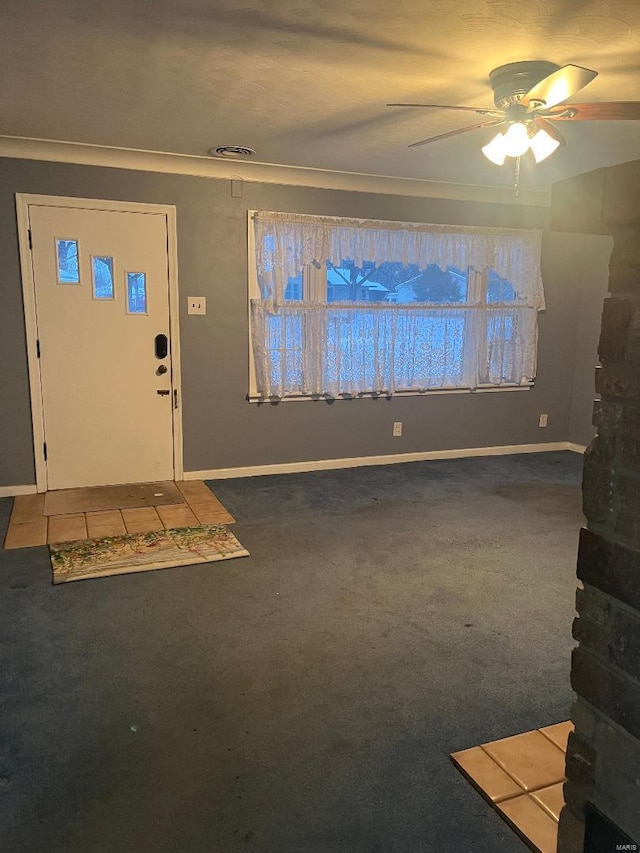 foyer entrance with dark colored carpet and ceiling fan