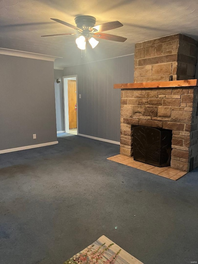 unfurnished living room featuring carpet, a stone fireplace, ceiling fan, and ornamental molding