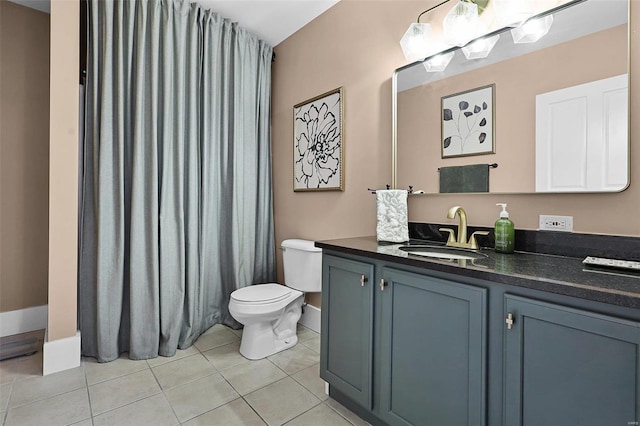 bathroom with toilet, vanity, and tile patterned floors