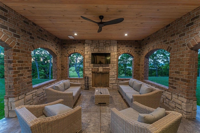 view of patio / terrace with an outdoor living space with a fireplace and ceiling fan