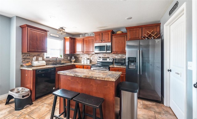 kitchen with appliances with stainless steel finishes, backsplash, a kitchen breakfast bar, sink, and a center island