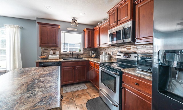 kitchen with appliances with stainless steel finishes, tasteful backsplash, and sink