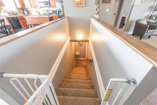 staircase with carpet floors and sink