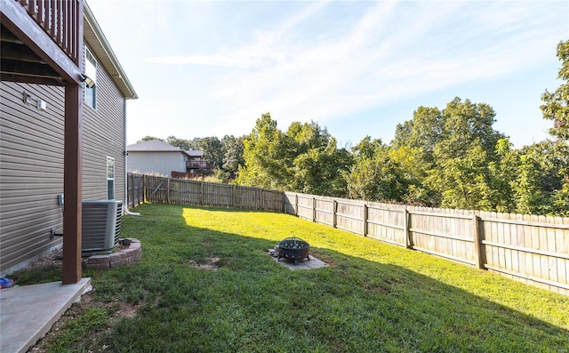 view of yard with central AC and an outdoor fire pit