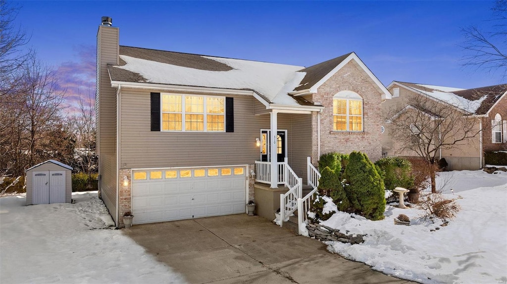 view of front of property featuring a storage unit and a garage