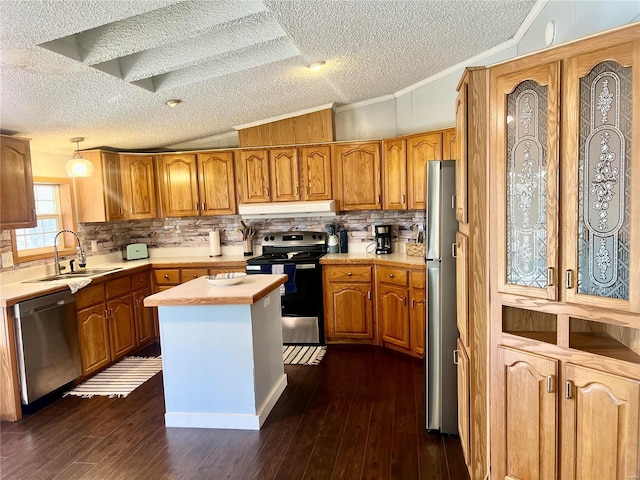 kitchen with a center island, sink, appliances with stainless steel finishes, and vaulted ceiling