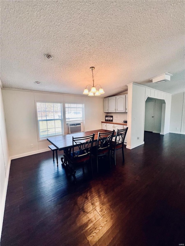 dining room featuring dark wood-type flooring, a textured ceiling, and a chandelier