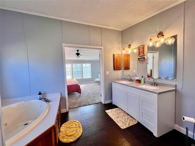 bathroom featuring ceiling fan, crown molding, hardwood / wood-style floors, a textured ceiling, and vanity