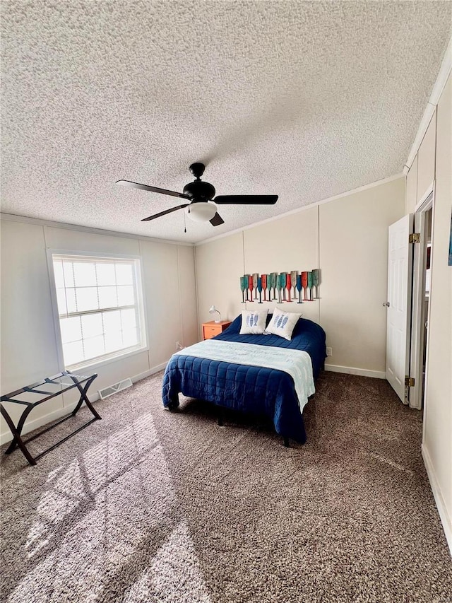 carpeted bedroom with ceiling fan, a textured ceiling, and ornamental molding