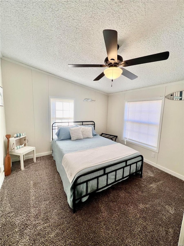 bedroom with dark colored carpet, ceiling fan, lofted ceiling, and a textured ceiling