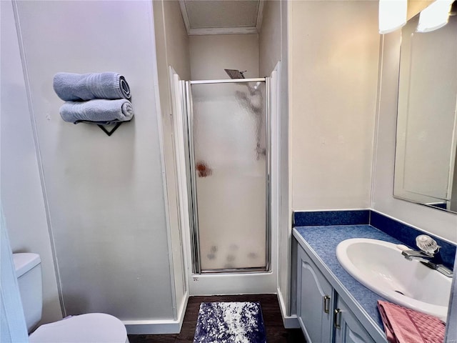 bathroom with ornamental molding, vanity, a shower with door, wood-type flooring, and toilet