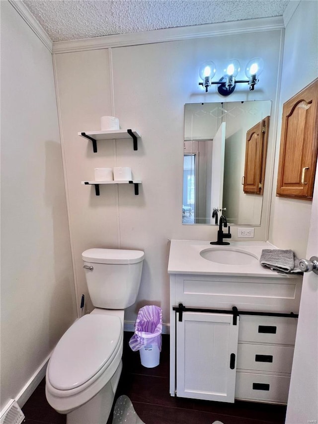 bathroom featuring vanity, a textured ceiling, toilet, and crown molding