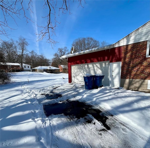 yard covered in snow featuring a garage