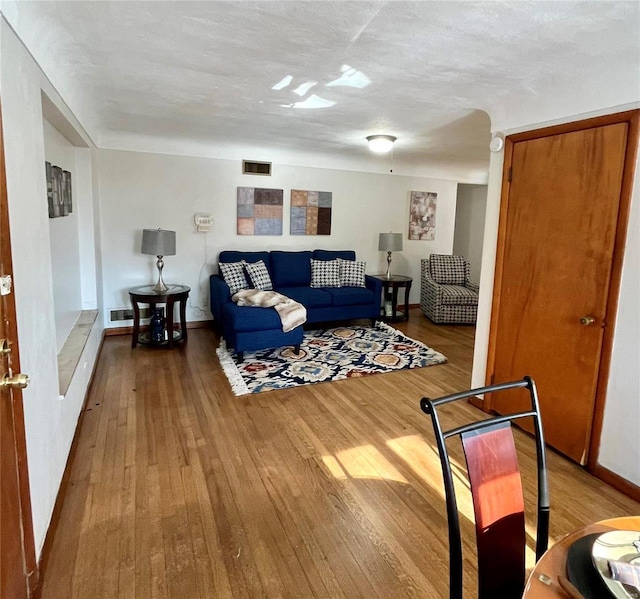 living room with hardwood / wood-style floors and a textured ceiling