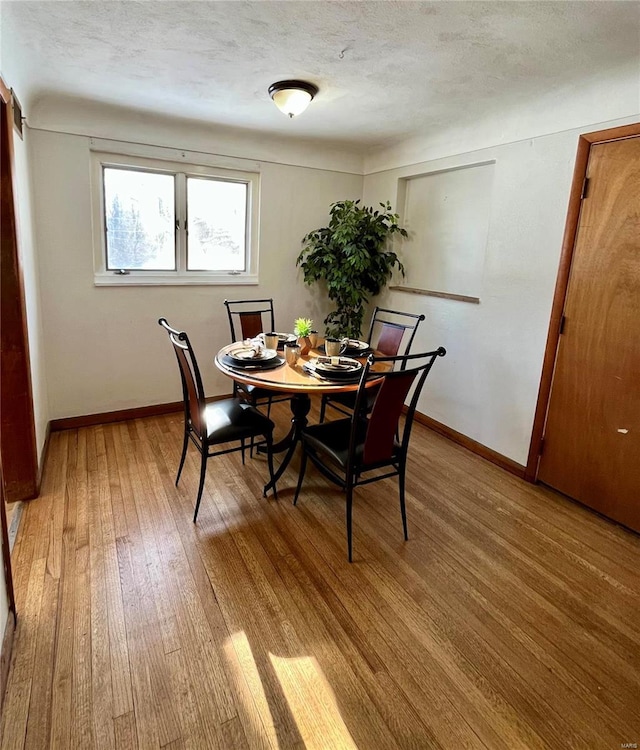 dining room featuring a textured ceiling and light wood-type flooring