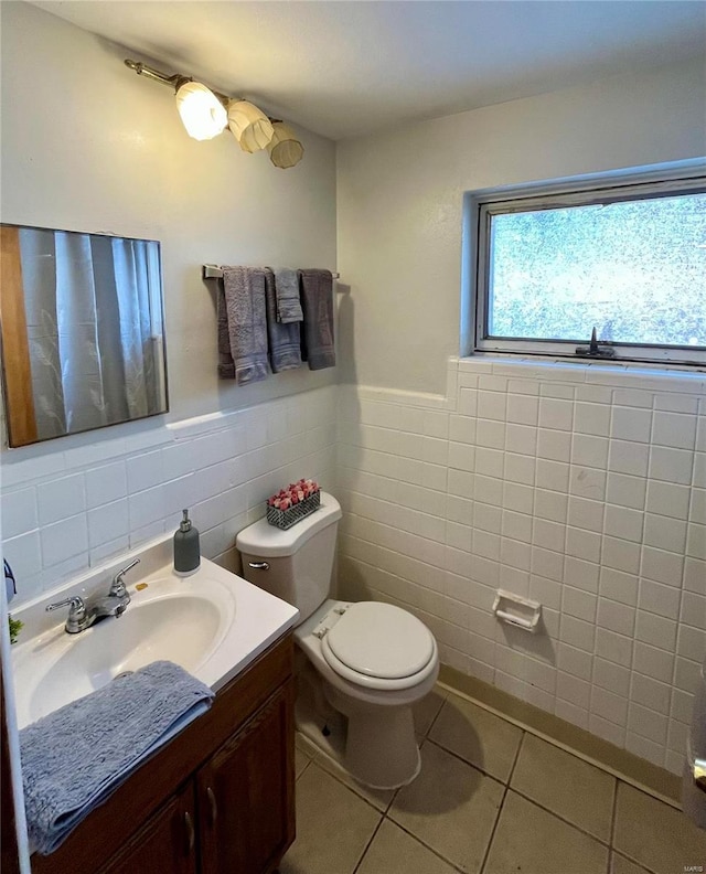 bathroom featuring tile patterned floors, vanity, tile walls, and toilet