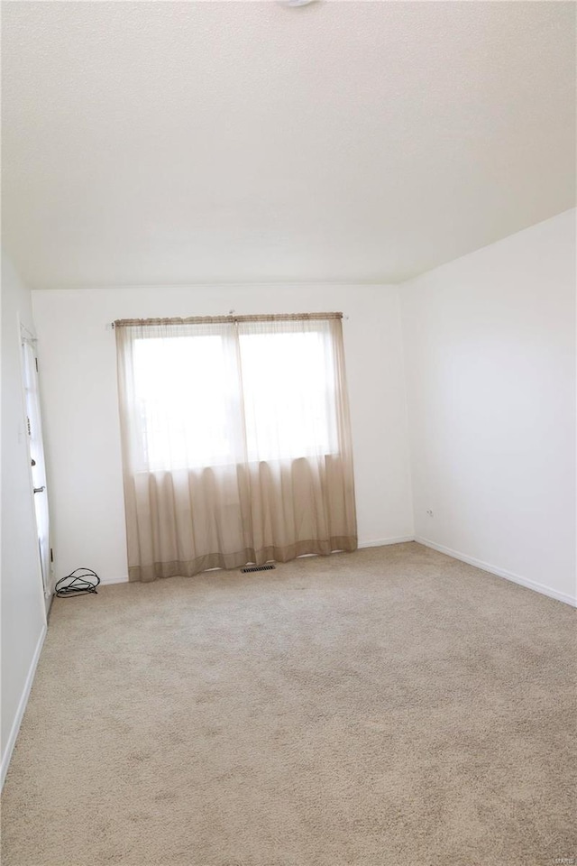 carpeted spare room with a healthy amount of sunlight