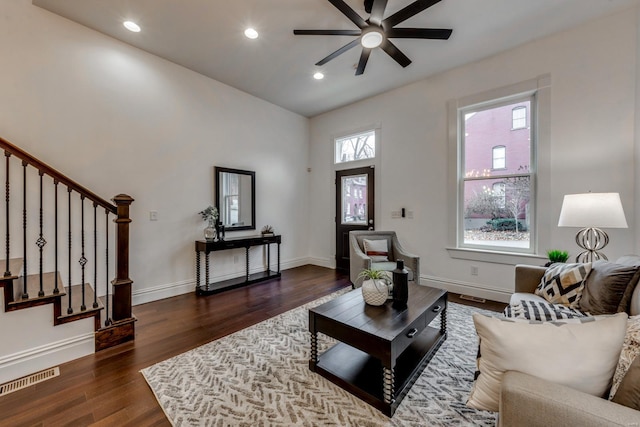 living room with ceiling fan and dark wood-type flooring