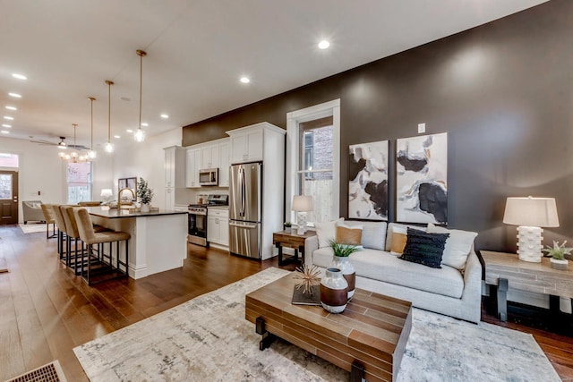 living room featuring ceiling fan, dark hardwood / wood-style floors, sink, and a wealth of natural light