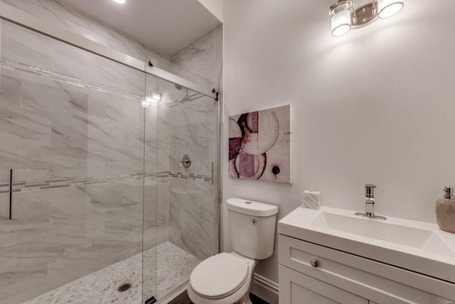 bathroom with vanity, a shower with shower door, and toilet