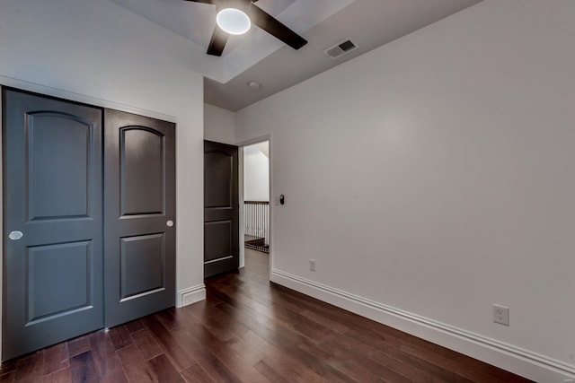 unfurnished bedroom with a closet, ceiling fan, and dark wood-type flooring