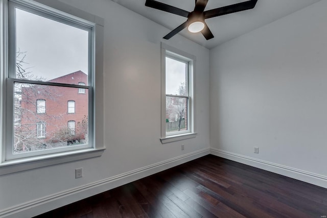 empty room with ceiling fan and dark hardwood / wood-style floors