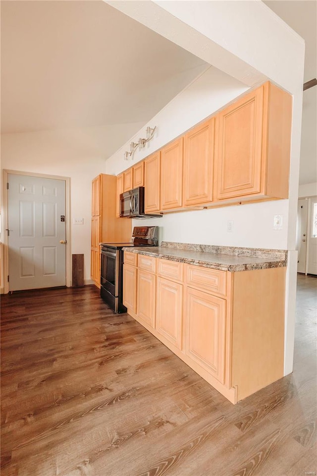 kitchen with light brown cabinetry, hardwood / wood-style floors, and stainless steel electric range