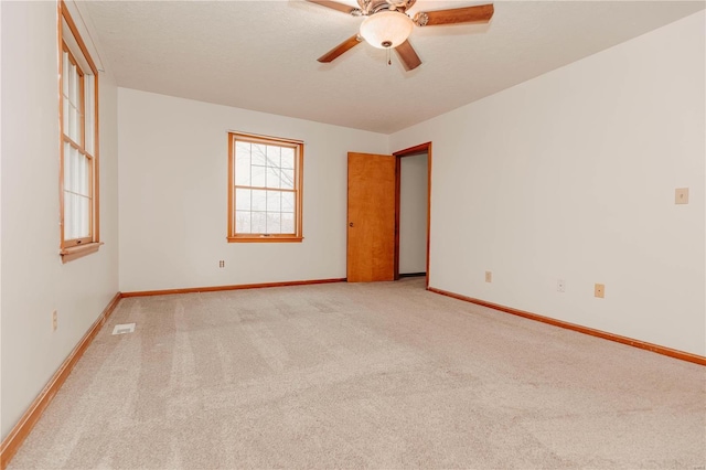 unfurnished room featuring ceiling fan and light carpet