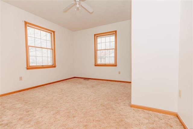 carpeted spare room with a healthy amount of sunlight and ceiling fan