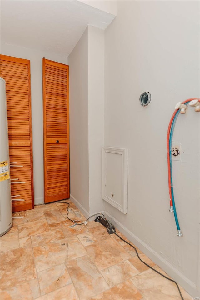 clothes washing area featuring water heater