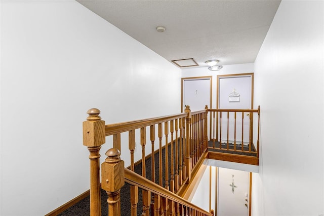 stairs featuring a textured ceiling