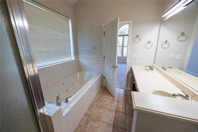 bathroom featuring tile patterned floors, vanity, and tiled tub