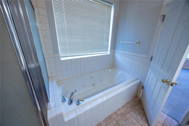 bathroom with tile patterned floors and a relaxing tiled tub