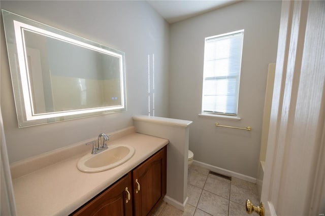 bathroom with toilet, vanity, and tile patterned floors