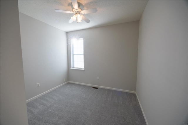 unfurnished room with dark colored carpet, ceiling fan, and a textured ceiling