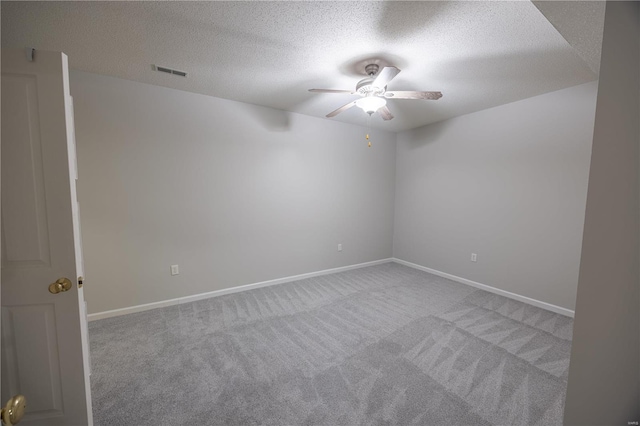 carpeted empty room featuring ceiling fan and a textured ceiling