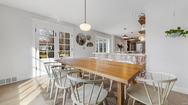 dining room featuring french doors, light hardwood / wood-style floors, and sink