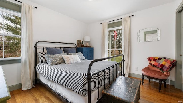 bedroom with wood-type flooring and multiple windows