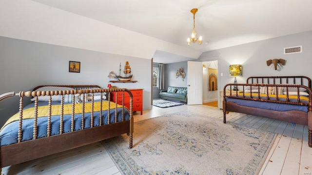 bedroom with light wood-type flooring and a notable chandelier