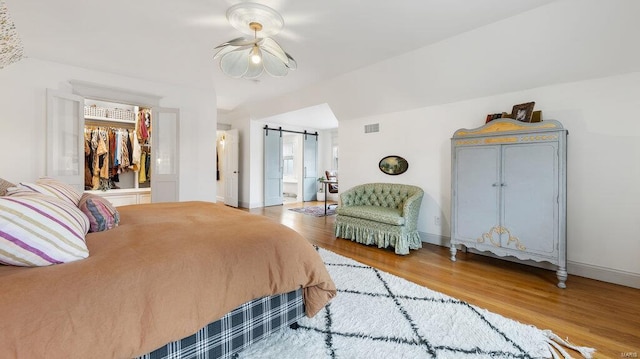 bedroom featuring hardwood / wood-style floors and a barn door