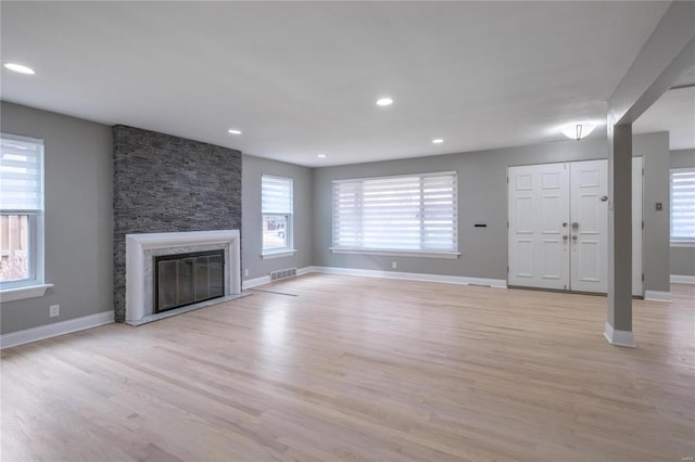 unfurnished living room with a fireplace and light hardwood / wood-style flooring