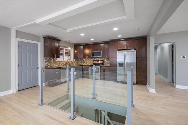 kitchen with sink, hanging light fixtures, stainless steel appliances, decorative backsplash, and dark brown cabinets