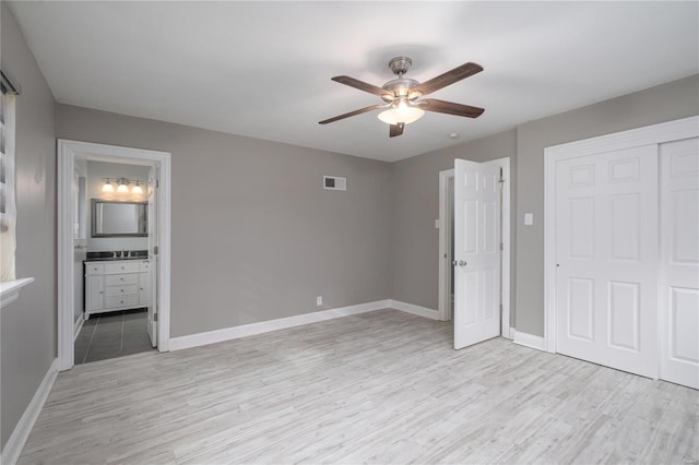 unfurnished bedroom with sink, ceiling fan, connected bathroom, light hardwood / wood-style floors, and a closet