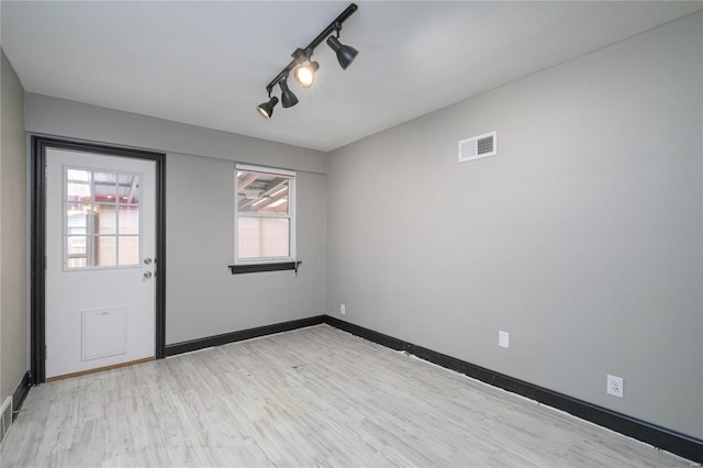 interior space with rail lighting and light hardwood / wood-style flooring