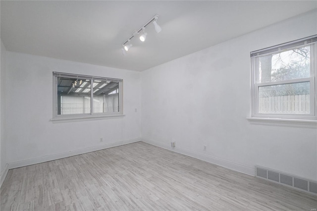 unfurnished room featuring light wood-type flooring and track lighting