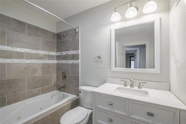 full bathroom with vanity, tiled shower / bath combo, and toilet