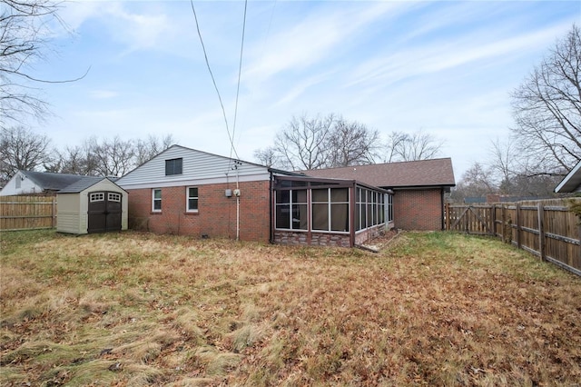 back of house featuring a sunroom, a storage unit, and a lawn