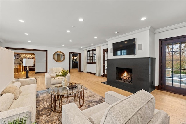 living room with crown molding and light wood-type flooring