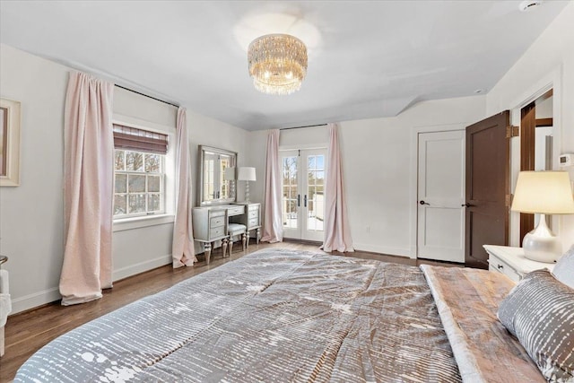 bedroom with hardwood / wood-style flooring, access to outside, french doors, and a chandelier